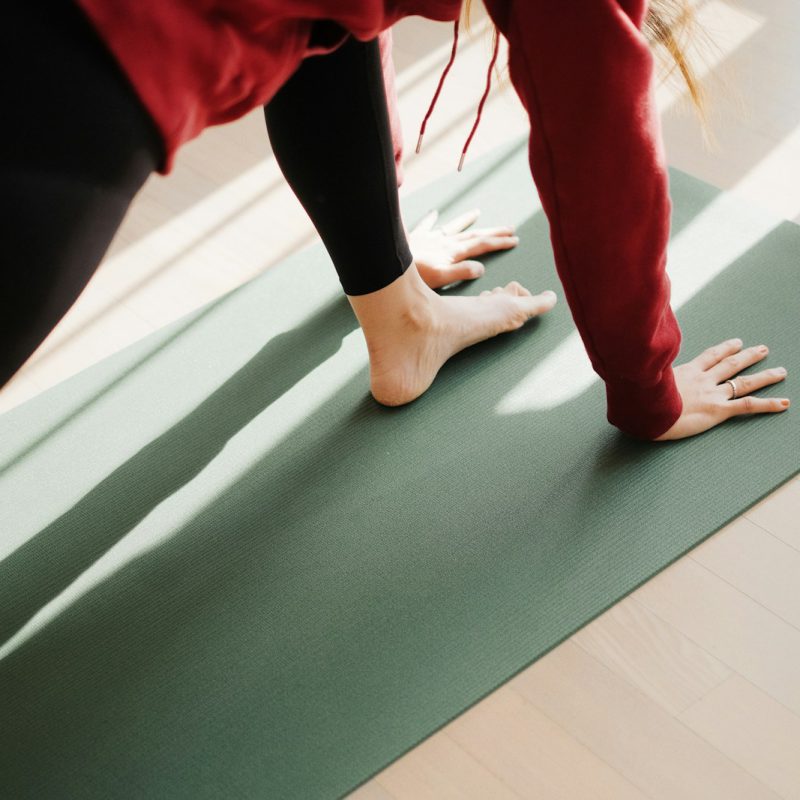 a person standing on a yoga mat on the floor