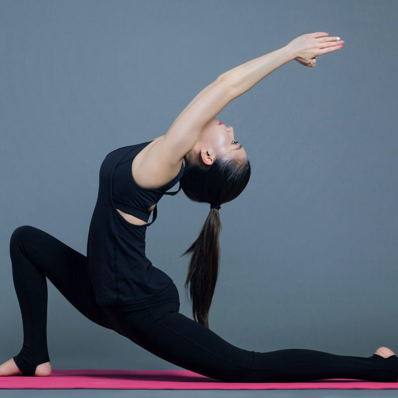 woman in black tank top and black pants doing yoga