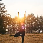 woman in black pants and pink shirt standing on green grass field during daytime