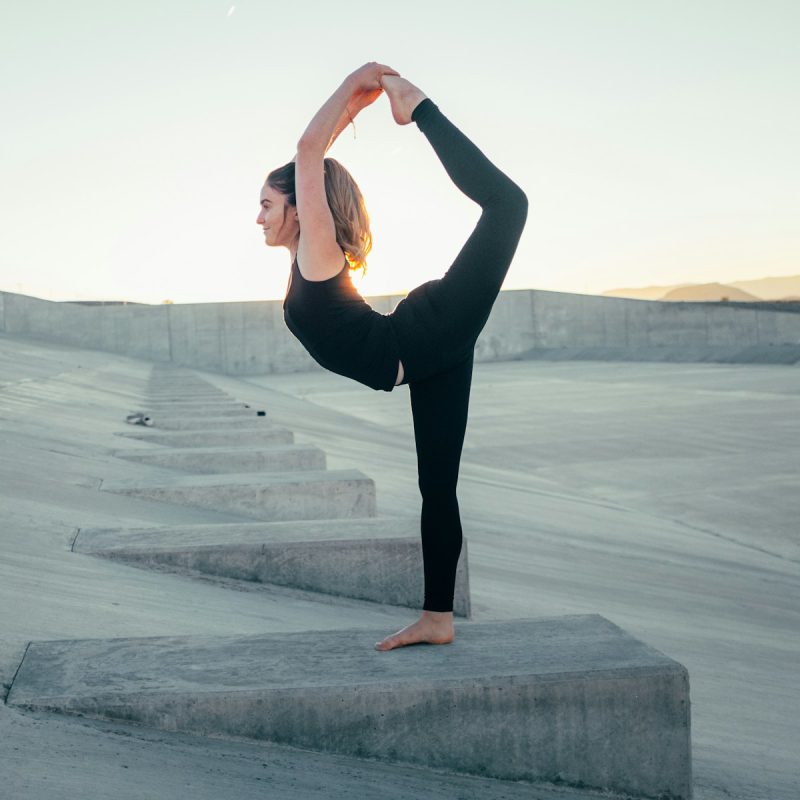 shallow focus photo of woman in black sleeveless shirt doing yoga