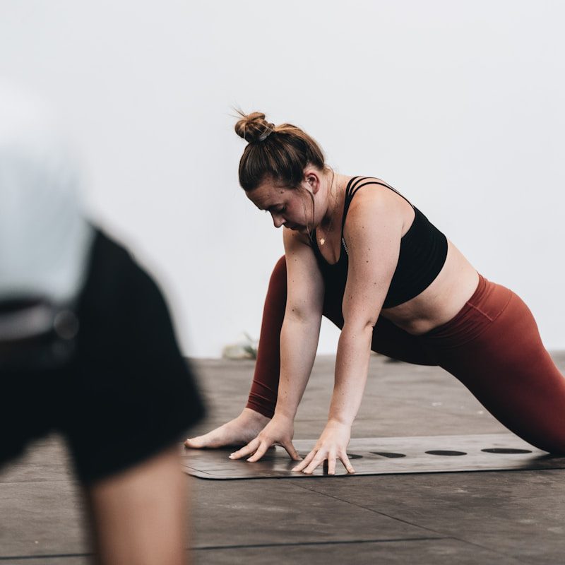 woman in black tank top and white pants doing yoga