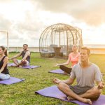 man in gray crew neck t-shirt sitting on green grass field
