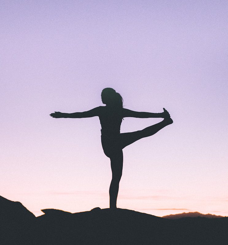 silhouette of woman doing yoga